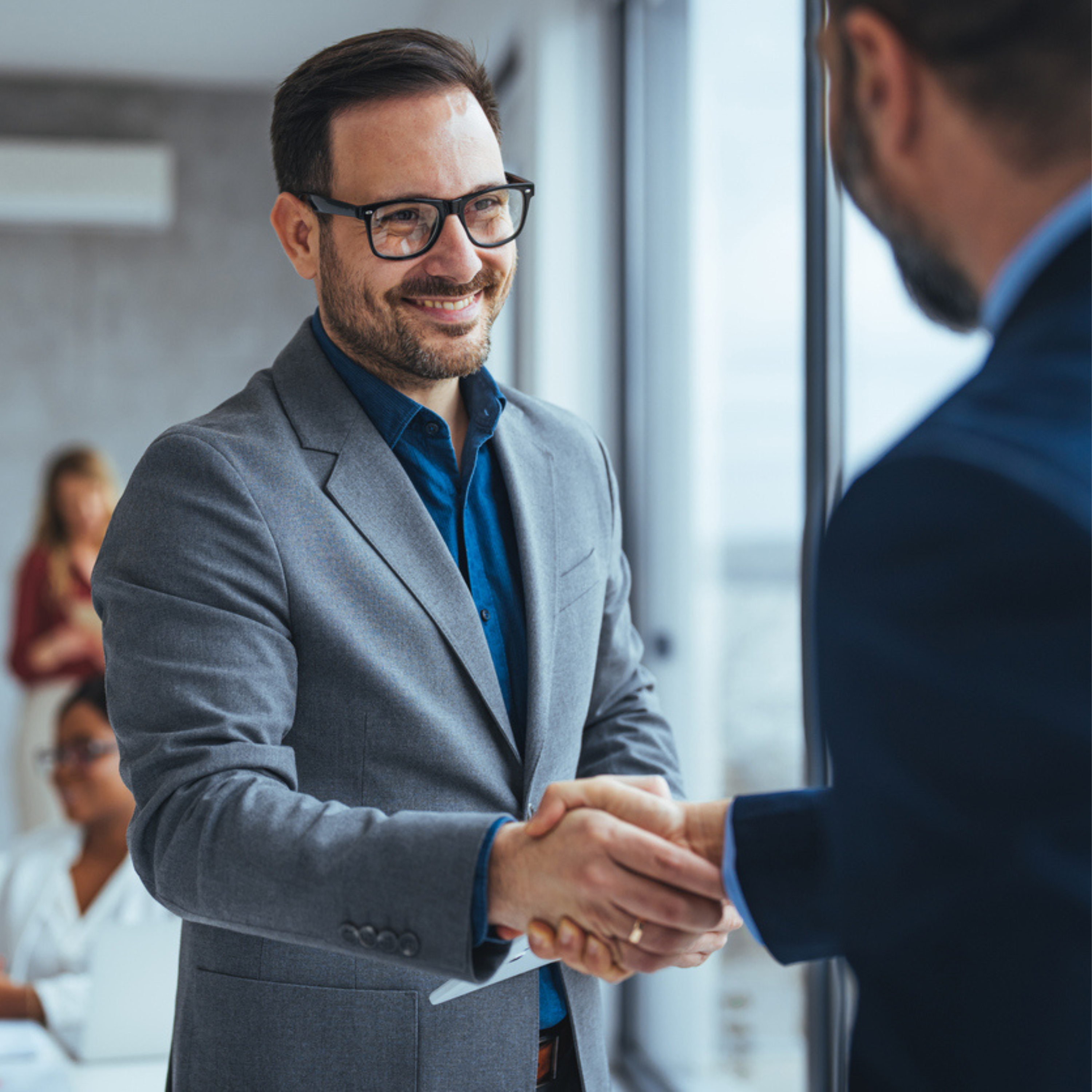 Muži si podávají ruce Podání rukou dvou businessmanů v kanceláři po úspěšné obchodní schůzce.